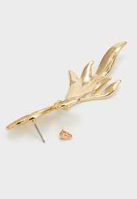 Gul broche formet som et blad med struktureret overflade og detaljerede årer. Har en metalnål bagpå og et medfølgende lille fastgørelseselement.