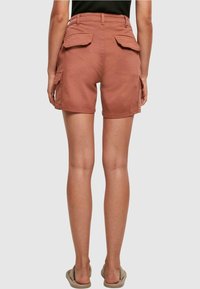 Shorts cargo couleur rouille avec deux poches arrière, taille haute et coupe décontractée, confectionnés en coton doux.