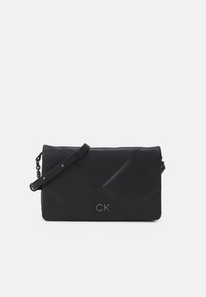 Sac en bandoulière noir matelassé en matériau synthétique, doté d'une sangle détachable et d'un logo embossé à l'avant.