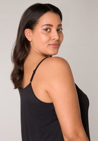 Zwarte camisole met dunne bandjes, gladde textuur en een aansluitend ontwerp. Zichtbare strap-aanpassingshardware op de achterkant.