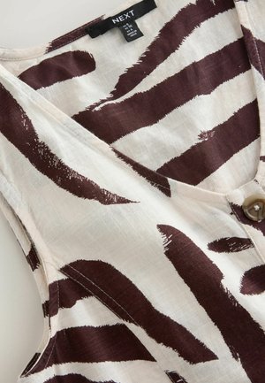 Ærmeløs bluse i hvid og mørkebrun zebra mønster, lavet af letvægtsstof, med V-hals og enkel knaplukning.