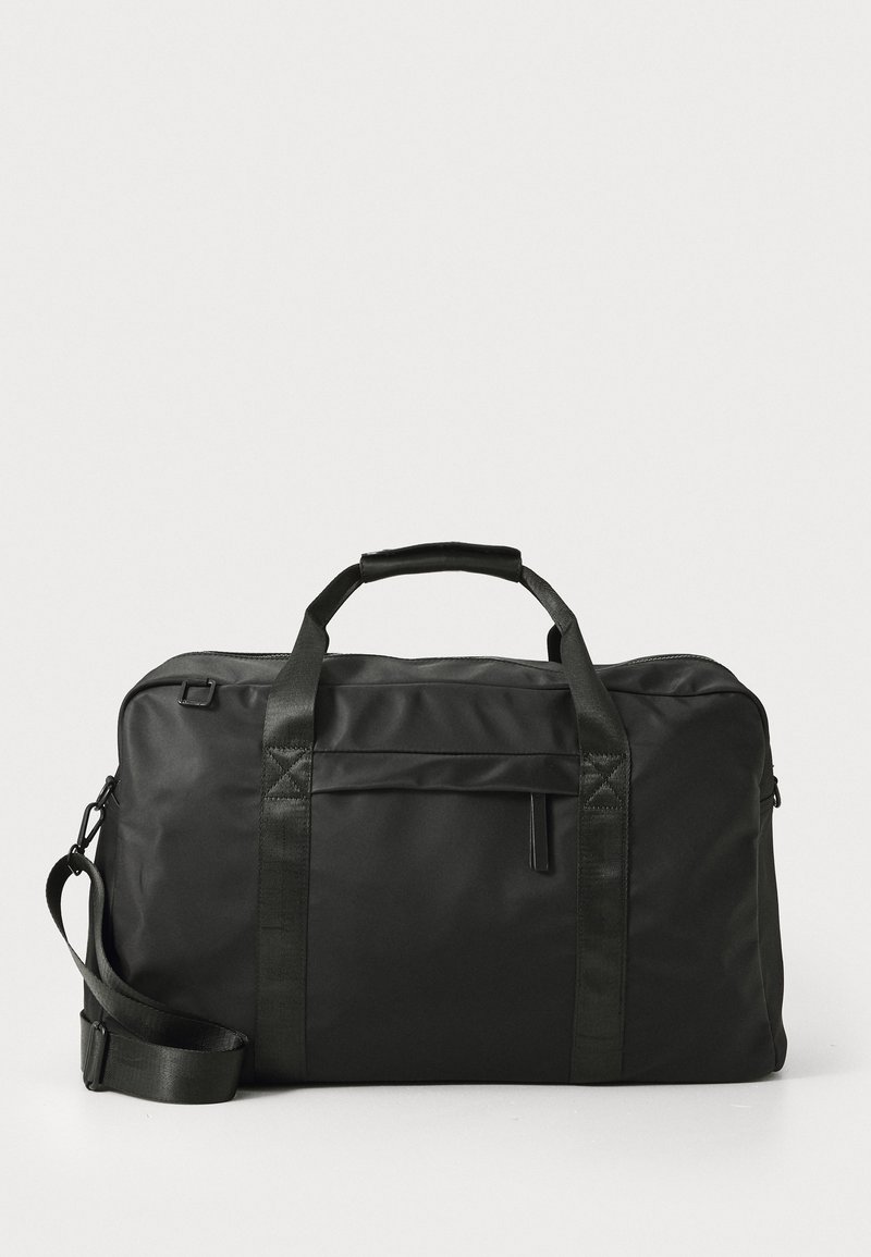 Czarna torba typu duffel, wykonana z trwałej tkaniny, wyposażona w dwa górne uchwyty, odpinany pasek na ramię oraz przednią kieszeń na zamek o minimalistycznym designie.