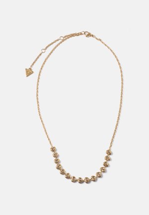 Gouden ketting met kleine hartvormige hangers, elk met een heldere steen, en een verstelbare sluiting met een driehoekig merkteken.