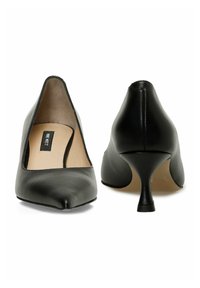 Čierne kožené lodičky na vysokom podpätku s špicatou špičkou, elegantným dizajnom a 7,5 cm kužeľovým podpätkom. Interiér má hladké béžové podšití.