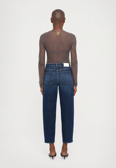 Langermige, doorschijnende bruine top met een getailleerd ontwerp, gecombineerd met hoge blauwe jeans met een rechte pijp en twee achterzakken.
