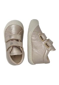 Zapatos metálicos dorados para bebés con dos tiras de Velcro. Punta redondeada, suela de goma texturizada y detalles de costura sutiles.