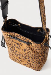 Borsa a secchiello in stampa leopardata realizzata in morbido suede con dettagli in pelle nera e accessori in oro. Design con apertura superiore e interni spaziosi.