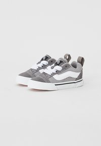 Graue Wildledersneaker mit weißen Schnürsenkeln und einem weißen Seitenstreifen. Das Design umfasst eine schwarze Außensohle und eine Schlaufe an der Ferse für ein einfaches Anziehen.