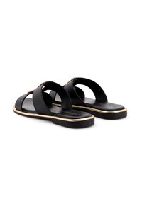Sandali in pelle nera con due fasce larghe, design open toe, dettagli dorati sulla suola e suola piatta nera.