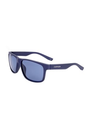 Occhiali da sole rettangolari blu Calvin Klein con montatura solida e lenti scure sfumate, inclinati verso destra su sfondo bianco.