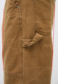 Καφέ καμβάς ποδιά με μια τσέπη στο μπροστινό μέρος, υφασμάτινη υφή και πλευρικό βρόχο. Ενισχυμένες ραφές κατά μήκος των άκρων.