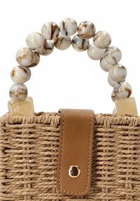 Bolso de paja tejido con una solapa de cuero marrón, que presenta un asa de cuentas redondas en diseño beige y marrón jaspeado con acentos cuadrados.