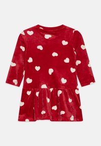 Robe en velours rouge à manches longues, avec un motif de coeurs blancs et une jupe évasée. Texture douce et encolure ronde.