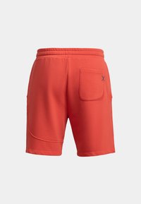 Shorts rossi in cotone con elastico in vita, dotati di tasca posteriore e cuciture curve. Tessuto morbido, taglio all'altezza del ginocchio.