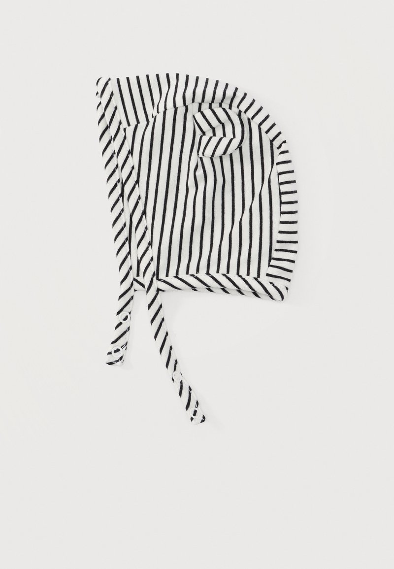 Βρεφικό σκουφάκι με ασπρόμαυρες ρίγες και κορδόνια που επεκτείνονται από κάθε πλευρά, τοποθετημένο επίπεδα σε λευκό φόντο.