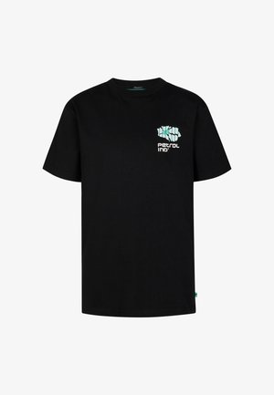 Czarny bawełniany t-shirt z grafiką z przodu, w połączeniu z miętowozielonymi kąpielówkami z czarną metką. Białe buty sportowe i skarpetki.