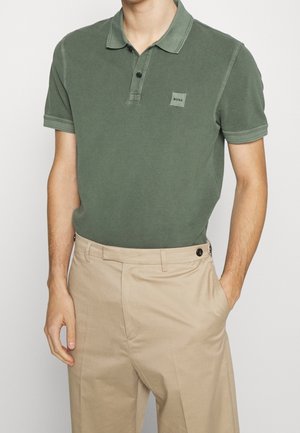 Polo vert en tissu doux, doté d'un petit col, d'une patte à deux boutons et d'un petit patch logo "BOSS" sur la poitrine.