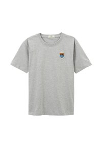 T-shirt en coton gris à manches courtes et col rond. Présente un petit patch brodé avec une montagne et du texte sur le côté gauche de la poitrine.