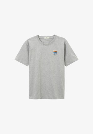 T-shirt en coton gris à manches courtes et col rond. Présente un petit patch brodé avec une montagne et du texte sur le côté gauche de la poitrine.