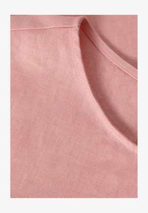 Light pink linen fabric with a textured surface. Features a rounded neckline and visible stitching along the edges. Soft and breathable material.