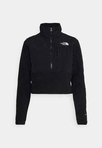 Pullover in pile nero, corto, con colletto alto, zip frontale e tasca al petto sinistro. Presenta il logo The North Face in bianco.