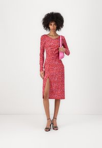 Rotes Leopardenmuster-Kleid mit langen Ärmeln, einem seitlichen Schlitz und Raffungdetails, kombiniert mit einer kleinen pinken Handtasche und schwarzen Riemchenschuhen.