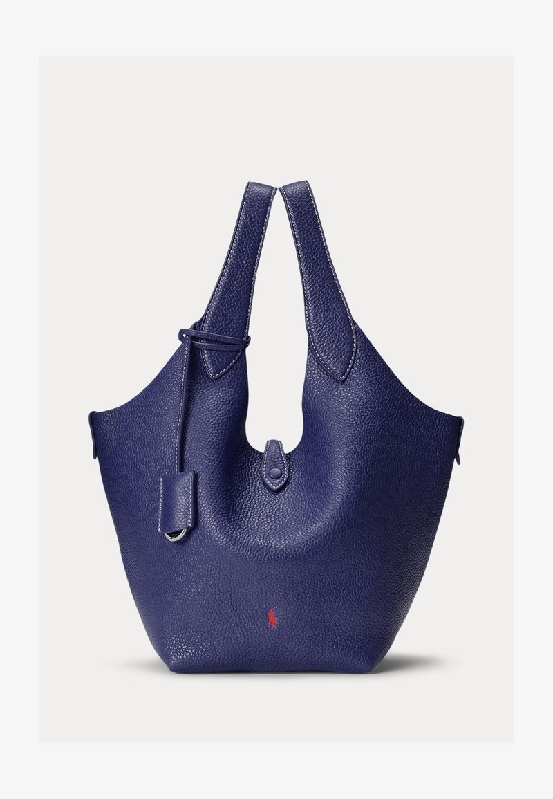 Grote donkerblauwe leren handtas met structuur, voorzien van dubbele handvatten, een klein voorvak met knoopsluiting en een subtiel rood logo nabij het midden onderaan.