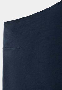 Tissu bleu marine foncé avec un petit détail de poche passepoilée horizontale visible près du bord gauche.