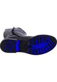 Stivale in pelle nera con tomaia testurizzata, dotato di una suola in gomma blu a contrasto. Logo e motivo della suola ben visibili.