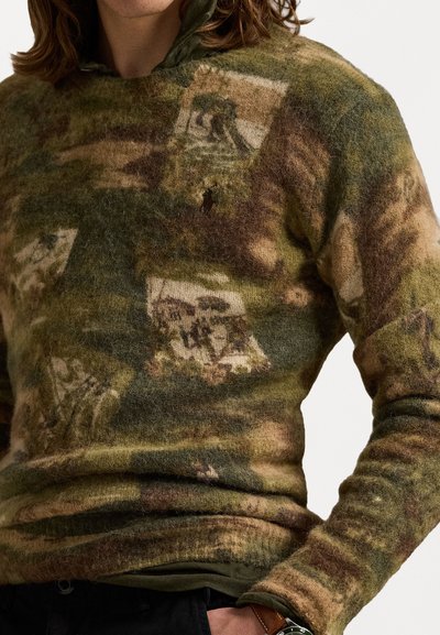 Gebreide trui in groene en bruine tinten, met een textuur en fuzzy oppervlak met fotografische patronen. Klassieke snit met een ribgebreide kraag.