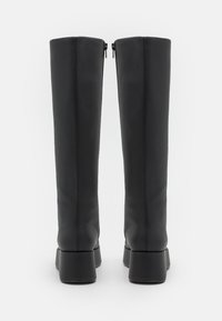 Botas de cuero negras hasta la rodilla con un acabado suave, que cuentan con un cierre de cremallera en la parte posterior y un tacón ancho para mayor estabilidad.