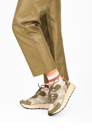 Lenkkitossut, joissa on beige verkkopäällinen ja oliivinvihreät mokkanahkaiset koristeet, monivärisillä heijastavilla yksityiskohdilla ja paksu valkoinen pohja.