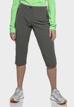 Graue, gekürzte Hosen aus leichtem Material, mit mehreren Taschen und geradem Bein, kombiniert mit hellen Sportschuhen.