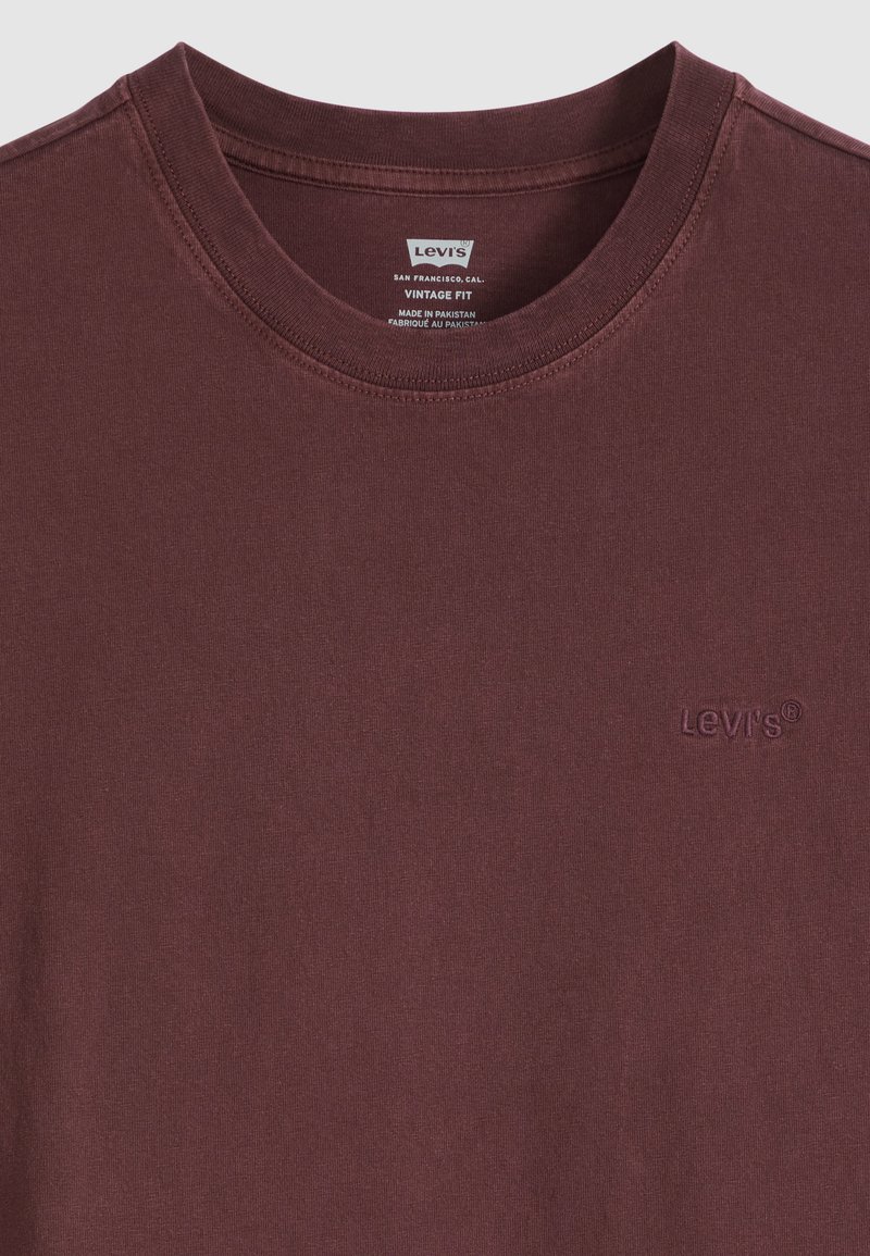 T-shirt marrone Levi's vintage fit con scollo a girocollo, logo ricamato sul petto ed etichetta stampata all'interno del colletto.