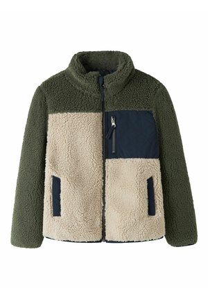 Bluza polarowa w kolorze oliwkowej zieleni i beżu z granatową pikowaną kieszenią na piersi, zamkiem błyskawicznym z przodu oraz dwoma bocznymi kieszeniami, stojąca pionowo na białym tle.