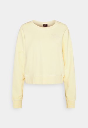 Kollane lühi-ülikond, millel on pikad varrukad, kõrged mansetid ja kaelus. Vasakul rinnal on õrn reljeefne logo. Pehme puuvillane segus.