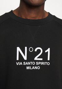 Felpa nera con tessuto testurizzato, colletto a costine e testo stampato bianco "N°21 VIA SANTO SPIRITO MILANO" sul davanti.