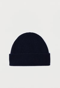 Laivastonsininen ribbineulottu pipo, jossa on käännetty resori, esillä yksinkertaisella valkoisella taustalla.