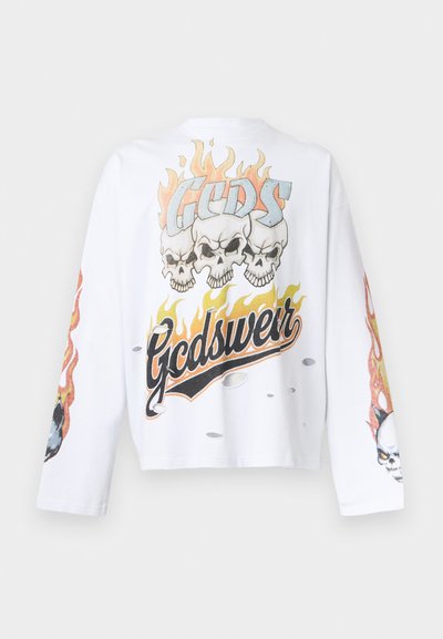 Λευκό μακρυμάνικο πουκάμισο με τρία κρανία πάνω από φλόγες και το κείμενο «Gcdswear», με σχέδια φλόγας και φθαρμένες τρύπες.