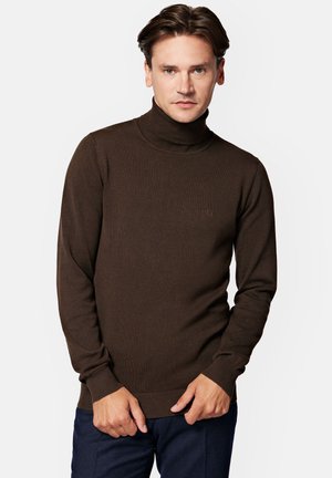 Brązowy sweter z golfem wykonany z dzianiny, z długimi rękawami, ribbowym kołnierzem i mankietami. Subtelny detal z logo na klatce piersiowej. Gładka, miękka tekstura.