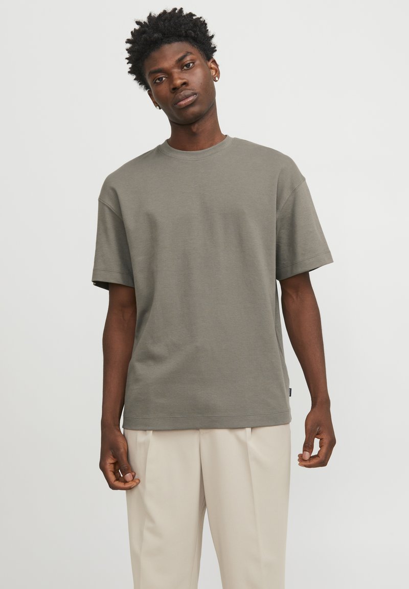 Oliven grøn t-shirt i bomuld med korte ærmer, rund hals og afslappet pasform. Har rene linjer og minimale syninger.