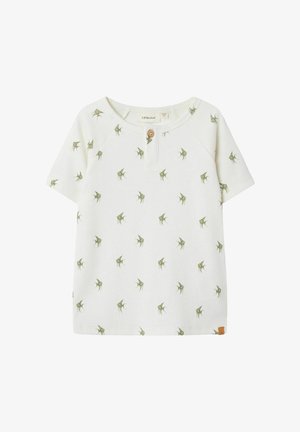 T-shirt blanc à manches courtes côtelé avec un col rond, présentant un motif de feuilles vertes et un détail de bouton en bois au niveau du cou.