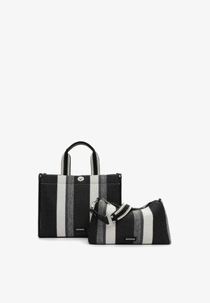 Deux sacs tissés rayés noirs, blancs et gris : un sac fourre-tout rectangulaire avec poignées, et un plus petit sac d'épaule incurvé avec une bandoulière ajustable.
