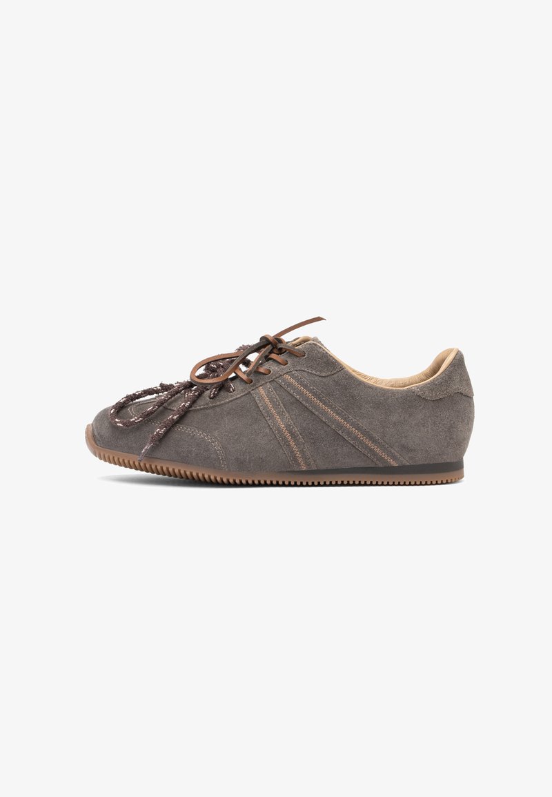 Baskets en daim marron avec coutures beige, lacets marron foncé et semelle en gomme nervurée, vues de profil sur fond blanc.