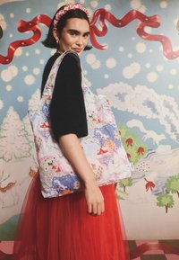 Nagy, színes bevásárlótáska játékos nyomattal, amely fákat és házakat ábrázol. Puha anyag, világos, párnázott textúrával.