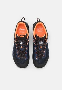 Pantofi sport navy și negri cu accente portocalii, prezentând un material superior din plasă texturată, șireturi cu un model distinct și o cutie pentru degete întărită.