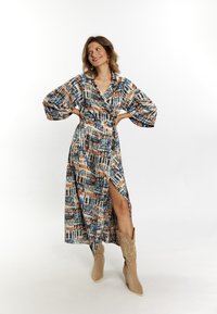 Vestido envolvente multicolorido con un atrevido patrón abstracto, que presenta mangas tres cuartos, una abertura lateral y una cintura atada. Tejido suave con un diseño fluido.