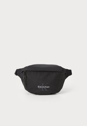 Svart midjeveske laget av slitesterk nylon, med en glidelåslomme og brodert logo. Kompakt og strømlinjeformet design. Justerbar stropp.