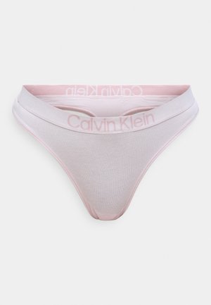 Calvin Klein kokvilnas stringi gaiši rozā krāsā ar platāku jostasviju, kas rotāta ar reljefotu logotipu. Mīksta tekstūra, minimālistisks dizains un zemu jostasvietu.