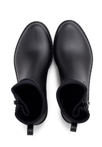 Botas de tobillo de goma negra con un acabado suave, punta redondeada y forro textil. Incluye una lengüeta en la parte posterior y un cierre de cremallera en el lateral.